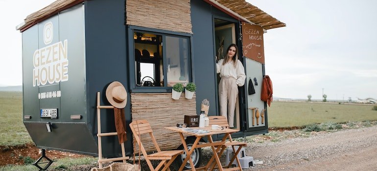 a woman in a little gray and wooden house