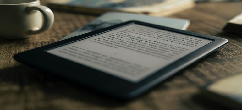 An e-book reader on a wooden table.
