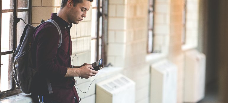 A student listening to music in a hallway.