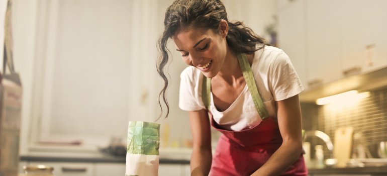 a woman cooking and considering how people can maximize space in small NYC apartments with storage units
