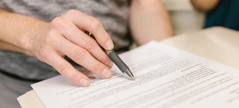 a person reviewing a lease agreement, which is what you should do before you decorate your rental apartment without risking your security deposit