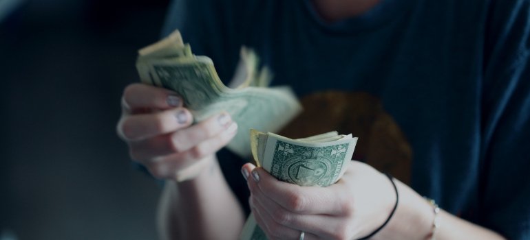 A woman counting the money she saved a few years after moving from Manhattan to the Bronx