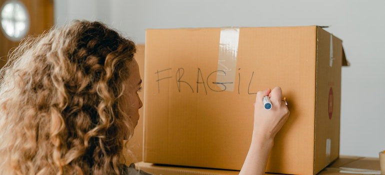 A person labeling a box before looking for the most reliable storage East Harlem has