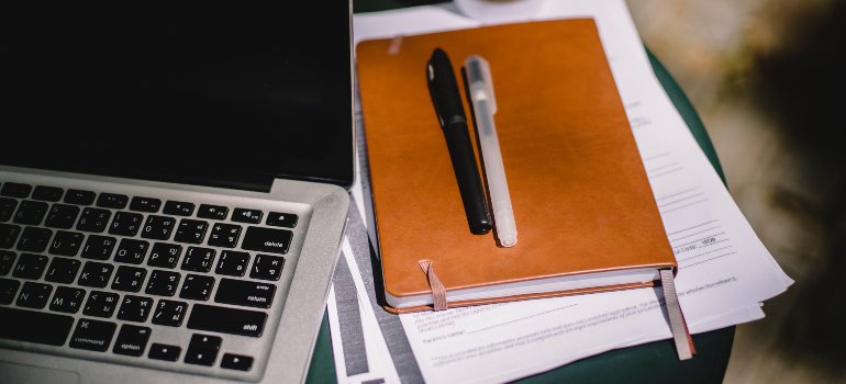 a laptop with a notebook next to it in one of the best Manhattan coffee shops for working remotely
