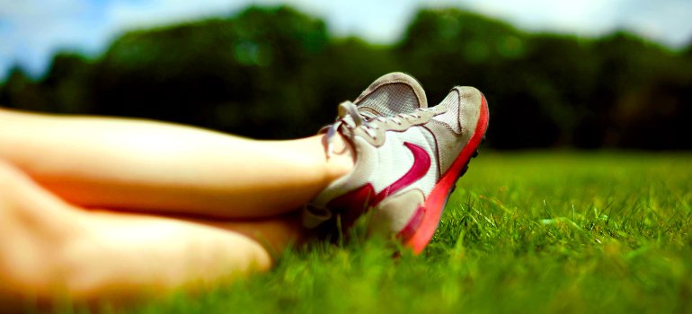 a person's legs resting on grass in the park
