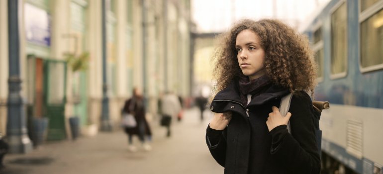 a tired-looking girl at a train station