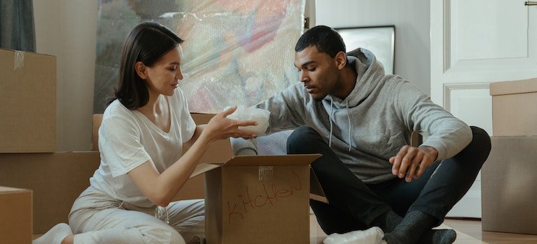 Two people decluttering their home and packing items they will secure at storage Hell's Kitchen locals recommend