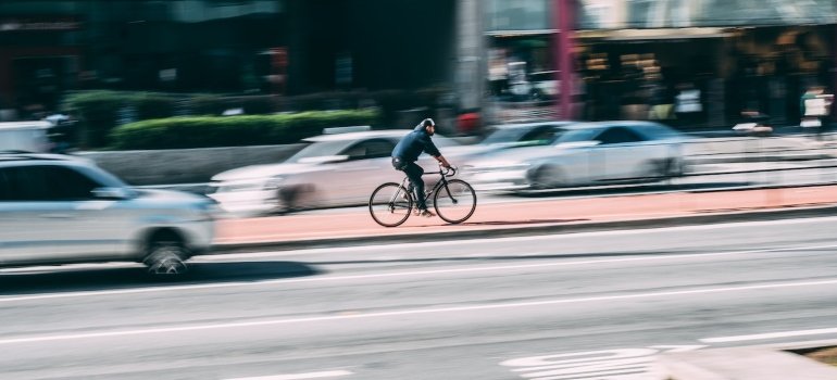 a man rides a bicycle in the middle of the city on a bicycle path after moving to Morrisania