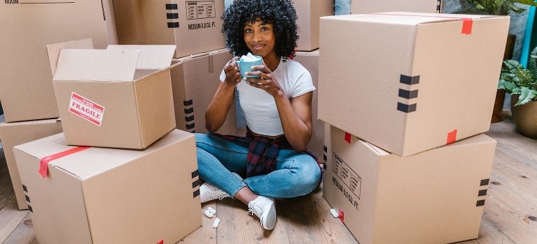 A person sitting, surrounded by boxes packed for self storage Port Morris locals recommend