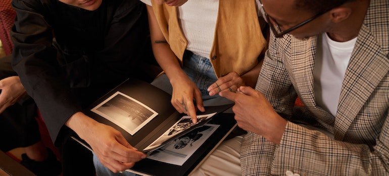 Three people looking at photos in a photo album