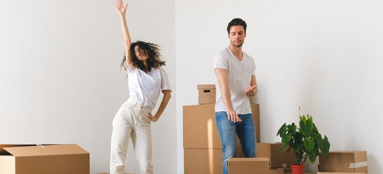 A couple dancing among cardboard boxes before moving to Morrisania