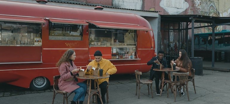 People eating in front of a food truck after moving to Mott Haven
