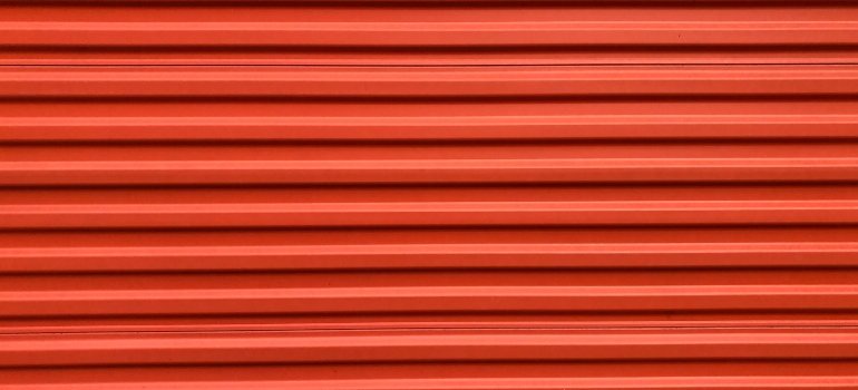 An orange metal door of a storage unit in Bedford Park NY