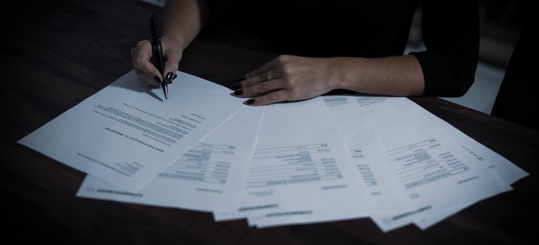 A person signing documents related to their new job after moving to Lower East Side