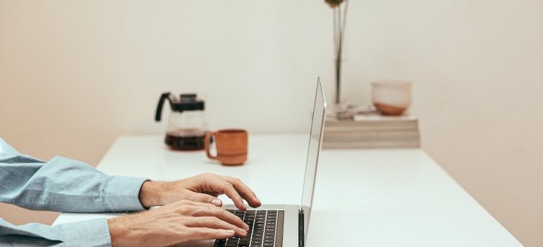 A person using a laptop to find suitable Manhattan storage