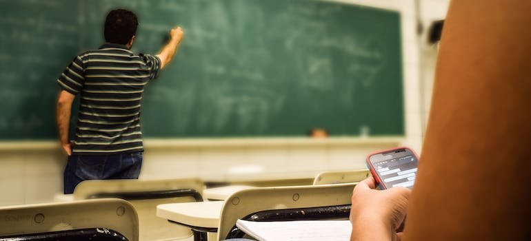 A teacher writing something on a board