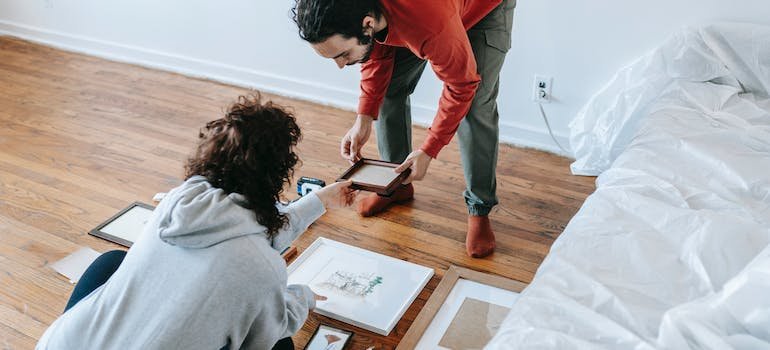 A couple picking a picture frame while discussing how to elevate their vacation rental
