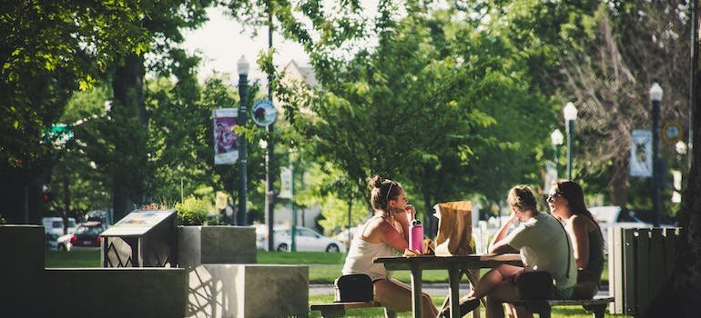 Three women sitting on benches while discussing the things to do in the Bronx.