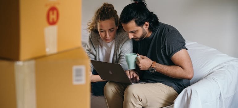 A couple using a laptop, looking for storage Washington Heights residents recommend