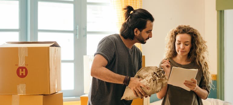 A couple writing something on a paper while packing