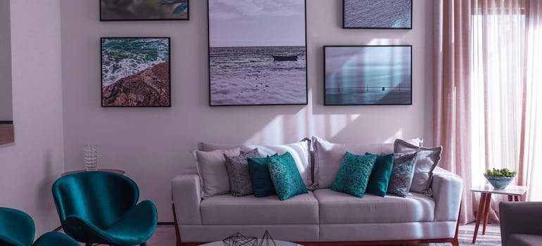 A living room with a white sofa and turquoise chairs