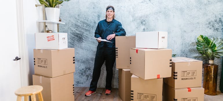 A person in a room full of boxes with items to be taken to a storage unit