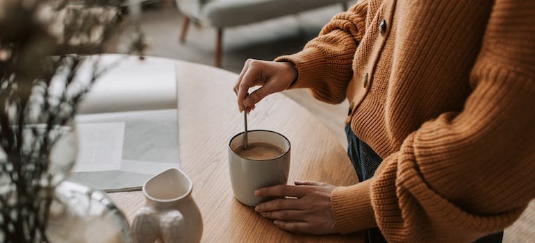 A person having coffee, which is something you can do after preparing your Manhattan apartment for winter
