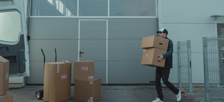 a mover carrying some boxes so he can help people have a stress-free move from Bronx to Manhattan