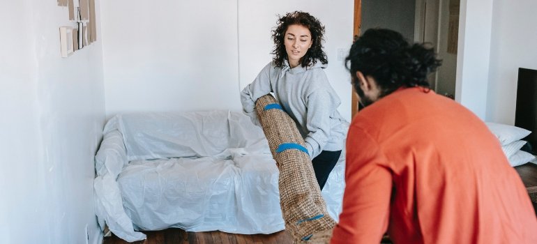 A couple carrying a rug