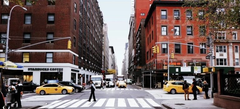 People and cars moving on the streets of NYC.