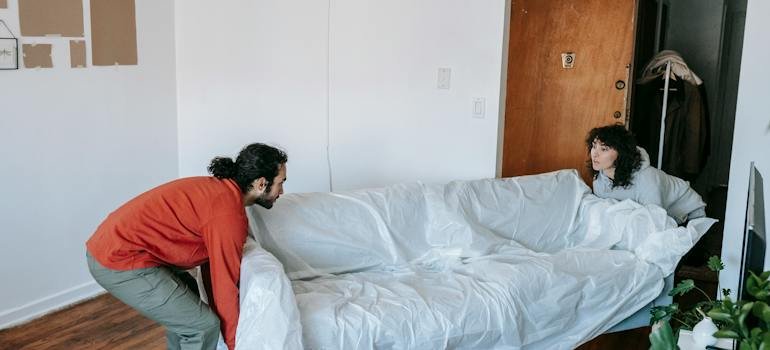 A couple carrying a sofa.