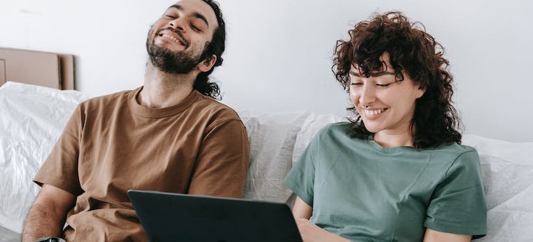A couple laughing after successfully moving between NYC boroughs.