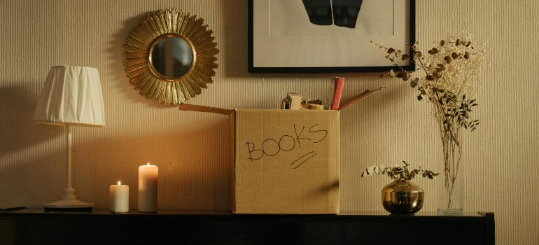 A cardboard box filled with books you can store and thus experience the perks of renting a storage unit in Manhattan.