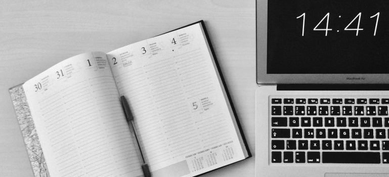 Planner next to a laptop to create a plan before you move from Lower Manhattan to Morningside Heights.