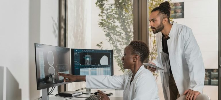Two doctors looking at medical records on computer screens