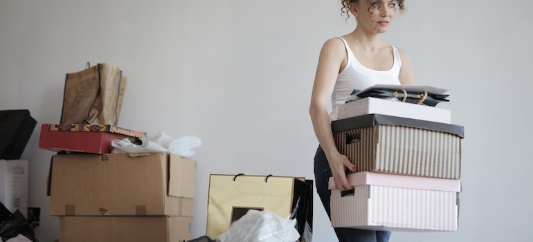 A woman carrying boxes and getting ready for a move.