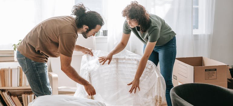 First-time storage renters wrapping up a chair