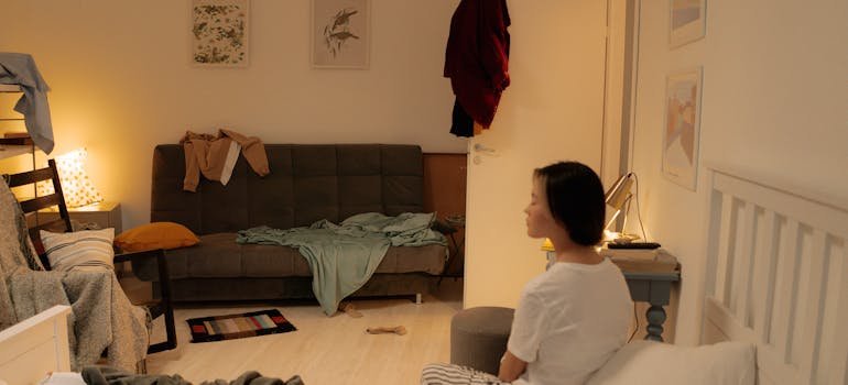 A woman in a white shirt thinking about the warning signs that you have too much stuff.