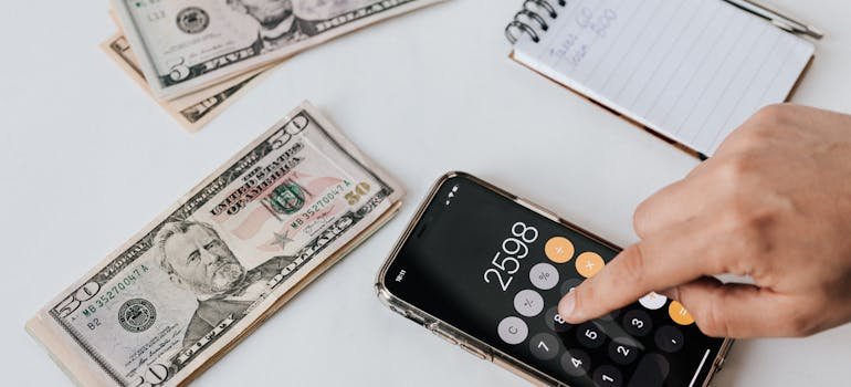 Calculator on a smartphone next to dollar bills