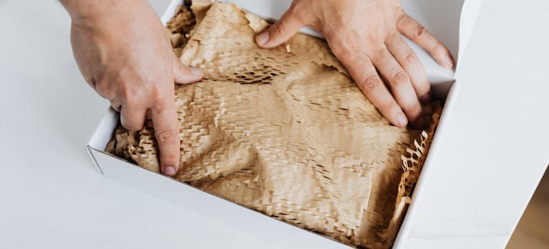 A person packing items in a box.