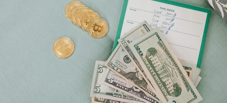 Dollar bills, coins and a notepad on a desk during the calculations before moving from Riverdale to Morrisania.