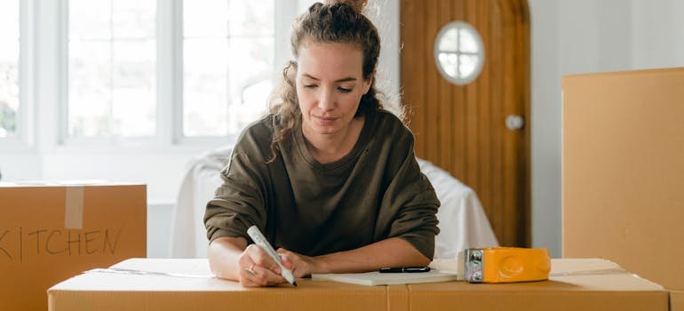 A woman looking labeling moving bixes while trying to prepare for a spring move to Manhattan
