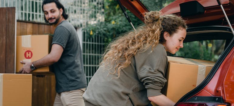A couple taking things out of a car during a moving.