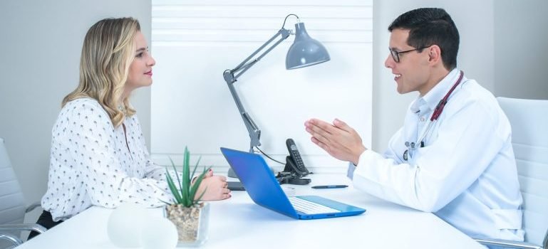 Woman talking to a doctor in his office