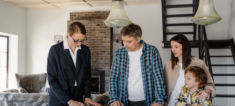 A real estate agen showing some papers to a family.