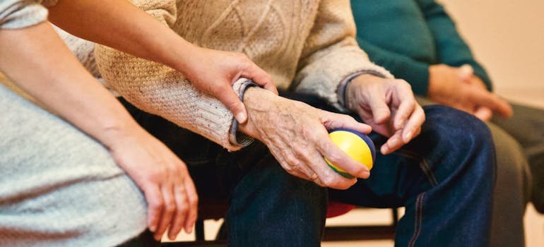 A person holding an elderly person's hand.