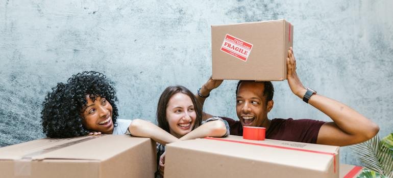 Three people with moving boxes