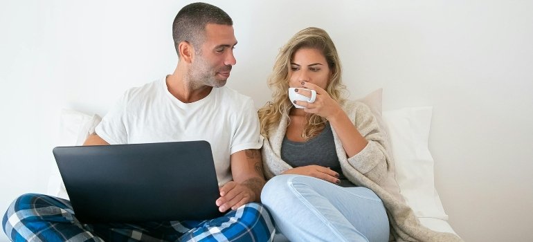 A couple reading about moving to Morningside Heights on a laptop.