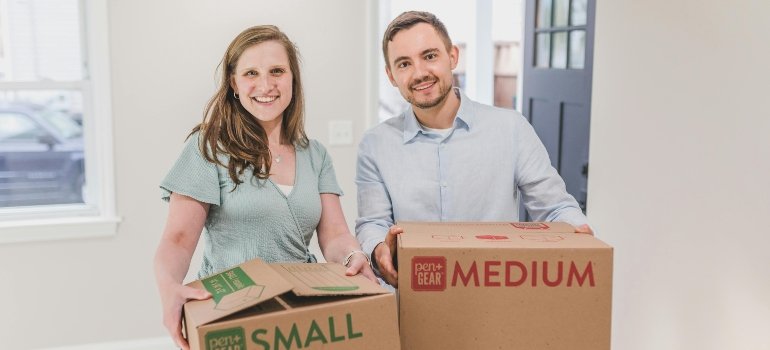 Two people carrying boxes