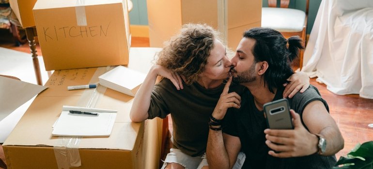 A couple kissing while preparing for moving from Wakefield to Castle Hill.